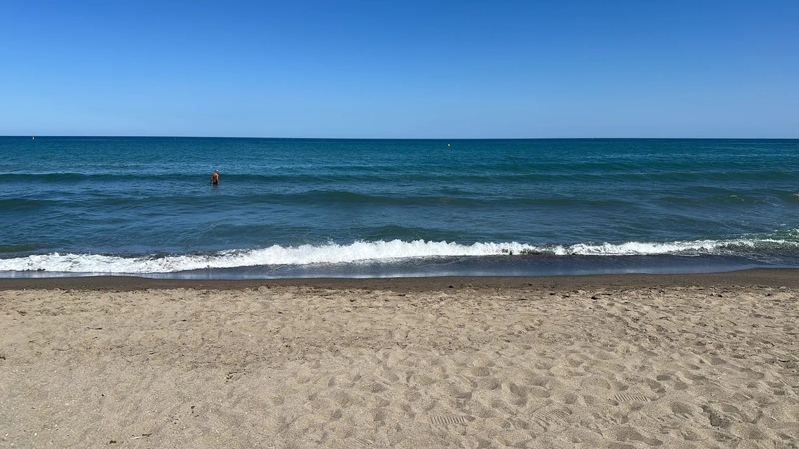 A swimmer in the sea at Bajondillo beach on a clear day